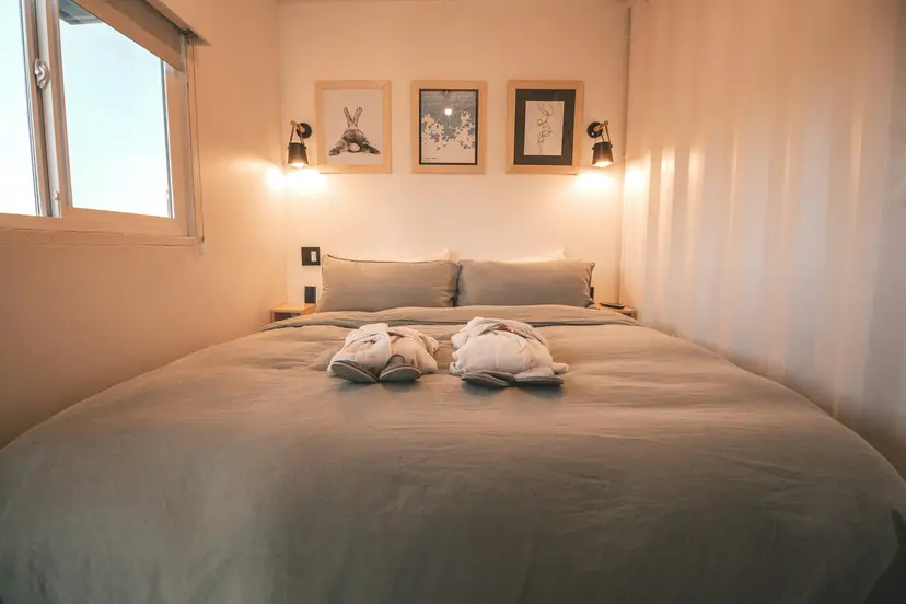 Two matching spa robes and slippers laid out in a softly lit room